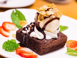 Класически сладкиш брауни с черен шоколад с декорация от бита сметана, ванилов сладолед и шоколадов сироп - снимка на рецептата